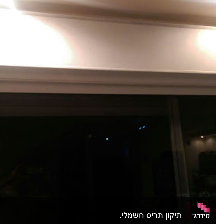 תריסים סגורים מעל חלון זכוכית גדול